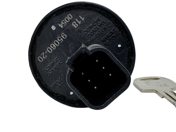 Black plastic component with printed text and a key for scale on a white background