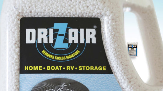 A close-up of a Dr. Zair moisture absorber container filled with white beads, featuring a black label with blue and yellow text.