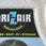 A close-up of a Dr. Zair moisture absorber container filled with white beads, featuring a black label with blue and yellow text.