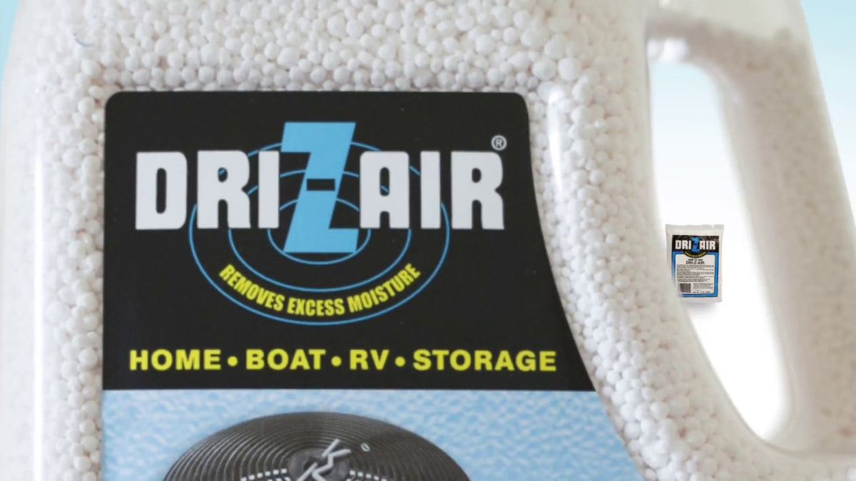 A close-up of a Dr. Zair moisture absorber container filled with white beads, featuring a black label with blue and yellow text.