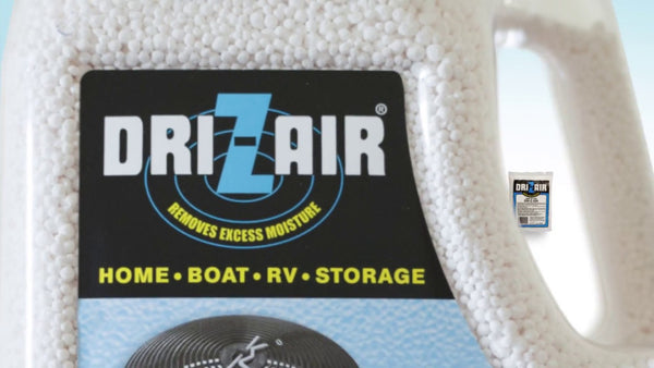 A close-up of a Dr. Zair moisture absorber container filled with white beads, featuring a black label with blue and yellow text.