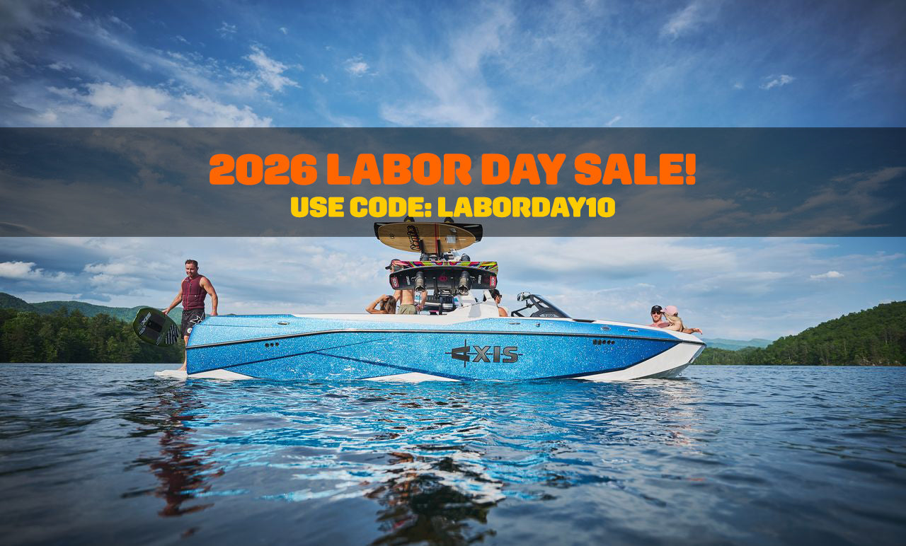 A blue and white Xfinity wakeboard boat on a lake with people on board, overlaid with a sale banner reading '2026 LABOR DAY SALE! USE CODE: LABORDAY10'.