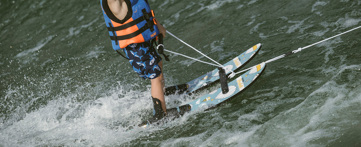 Child learning to water ski on Radar Firebolt combo skis