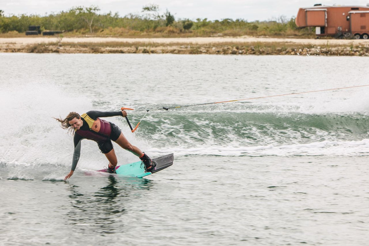 Female rider wakeboarding behind a boat on the Ronix Krush