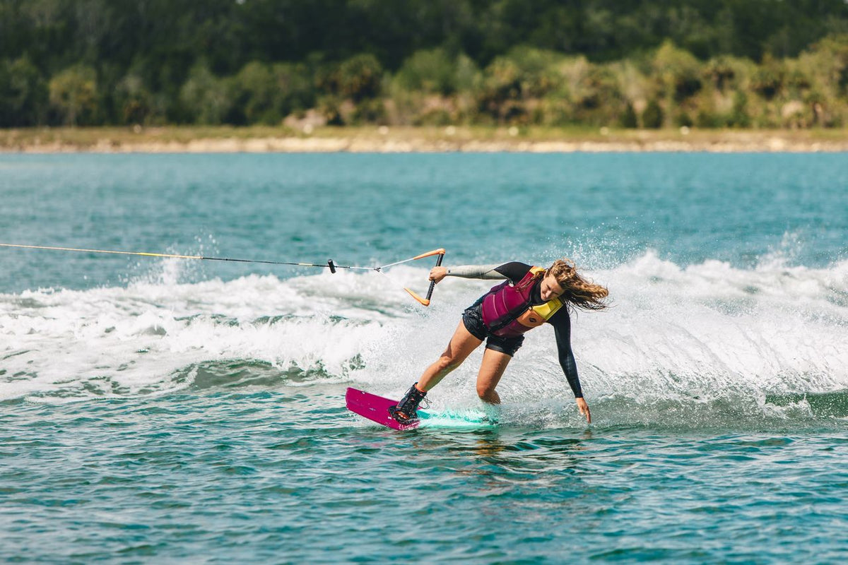 Female rider wakeboarding behind a boat on the Ronix Krush