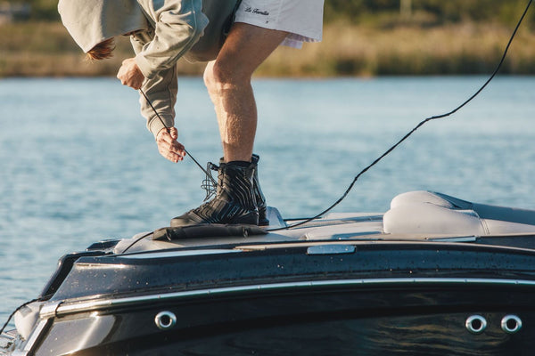 person on a boat wearing 2026 Ronix One Gloss Midnight Intuition closed-toe wakeboard boots