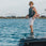 person wearing the 2026 Ronix One Silver Reflective Intuition closed-toe wakeboard boots on a boat